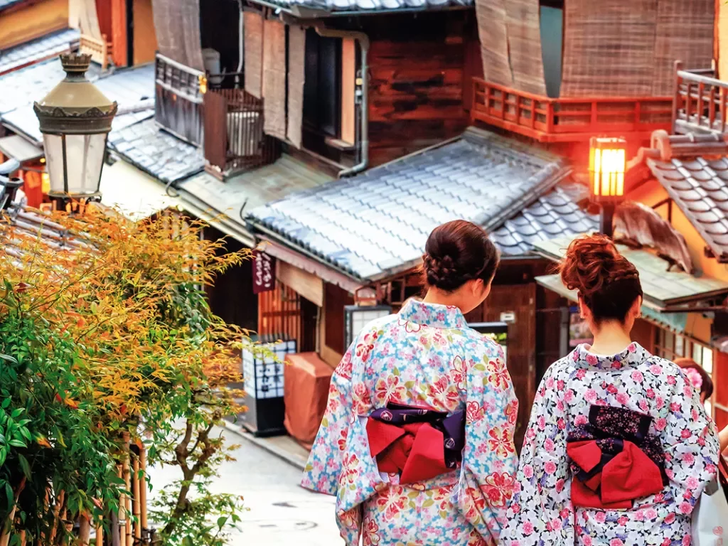Two Japanese woman in traditional clothing walking the streets 
