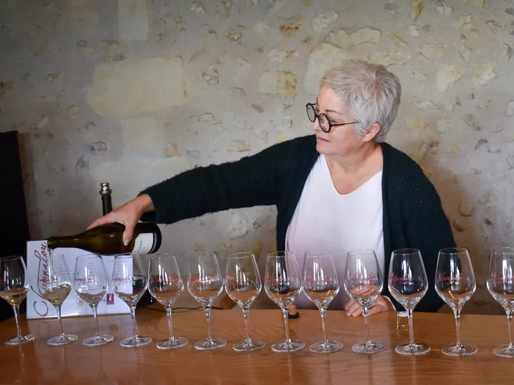 Woman pouring many glasses of wine.