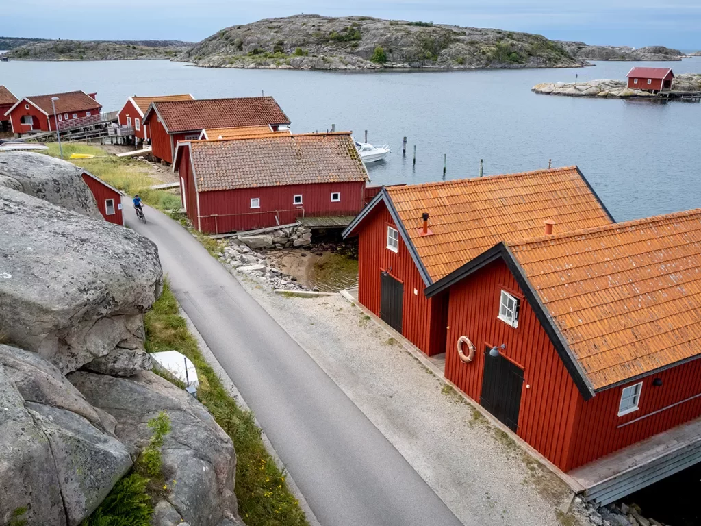 Row of red houses along a rocky shore in Norway