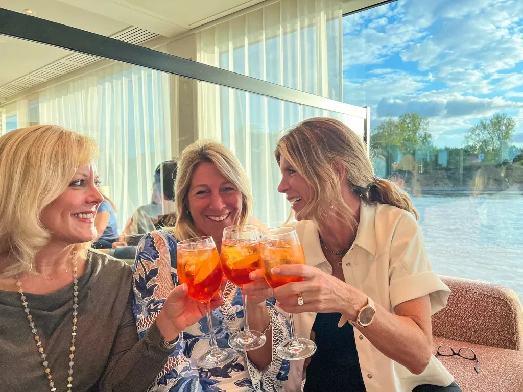 Guests with aperol spritzes raising a glass