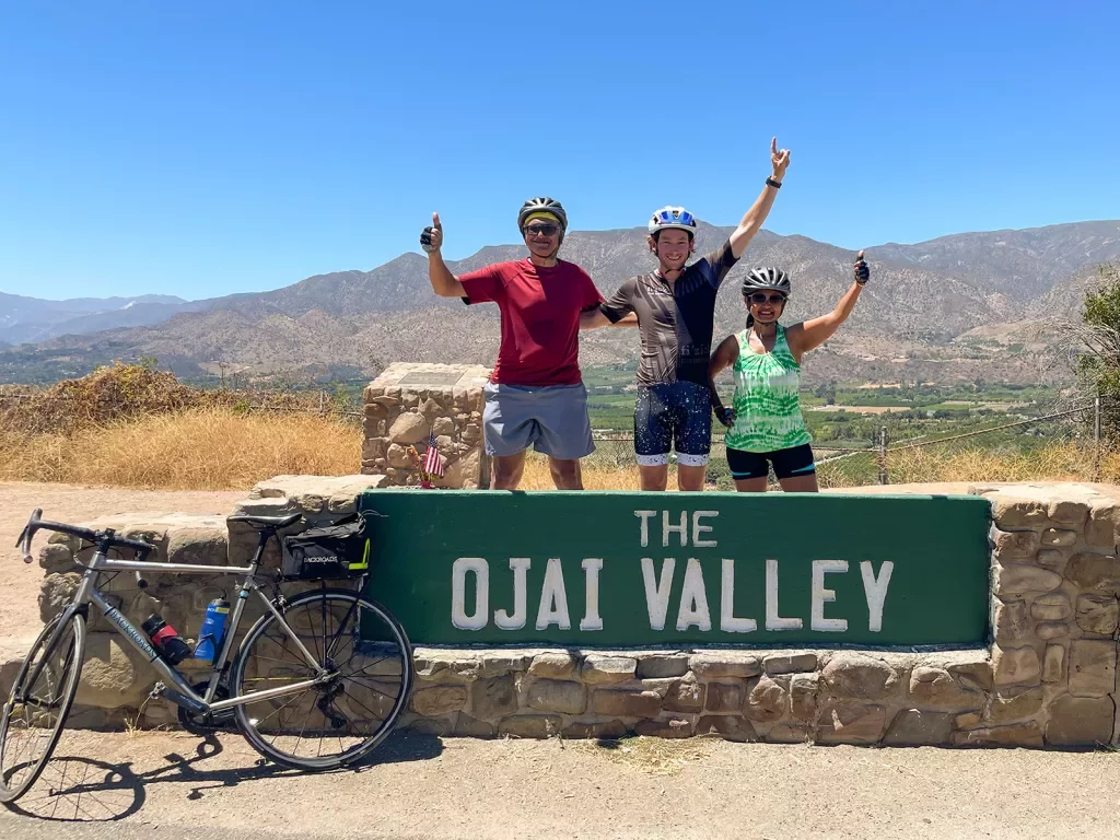Guests behind "OJAI VLLEY" sign.