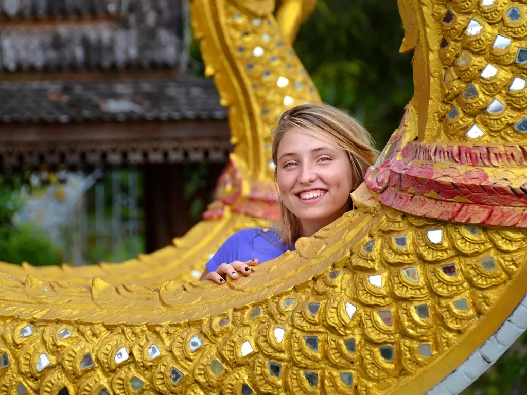Guest posing with a dragon statue in Thailand