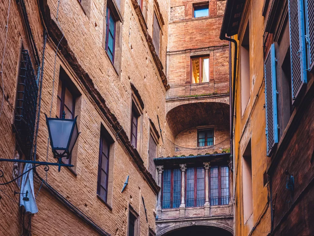 Shot of Italian alleyway, tall buildings, lamp.