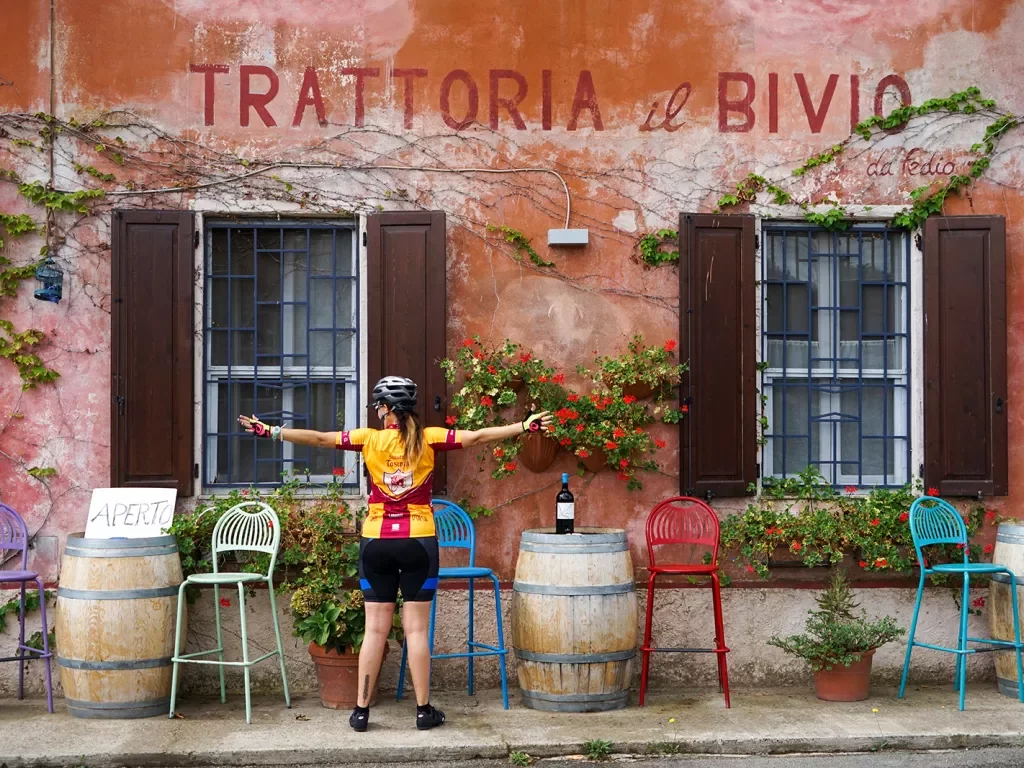 Storefront of "TRATTORIO IL BIVIO", guest with their arms outstretched. 