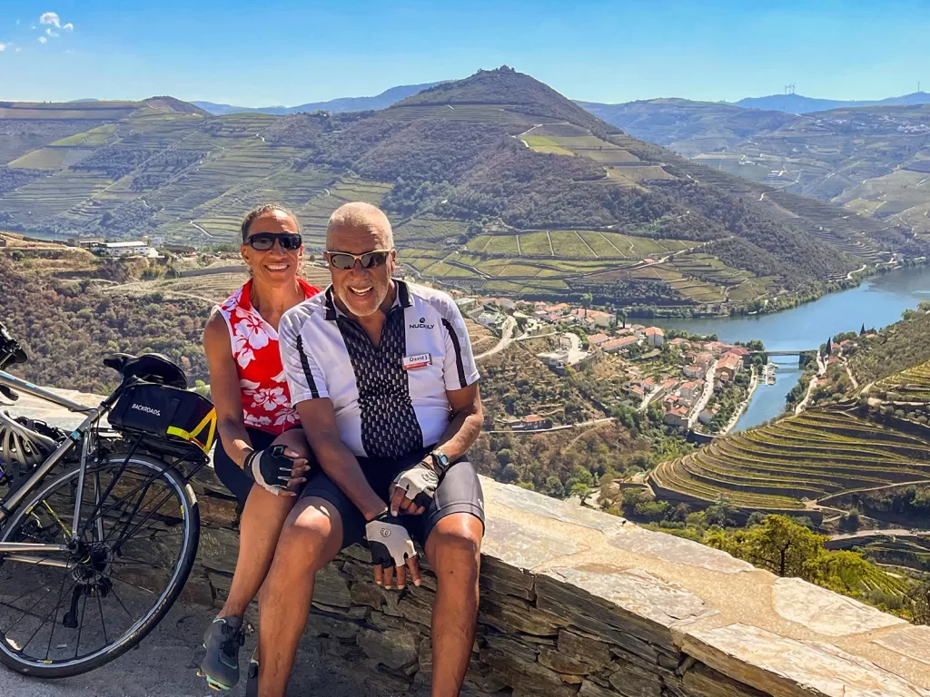 Two guests sitting on a stone wall overlooking the Douro River valley