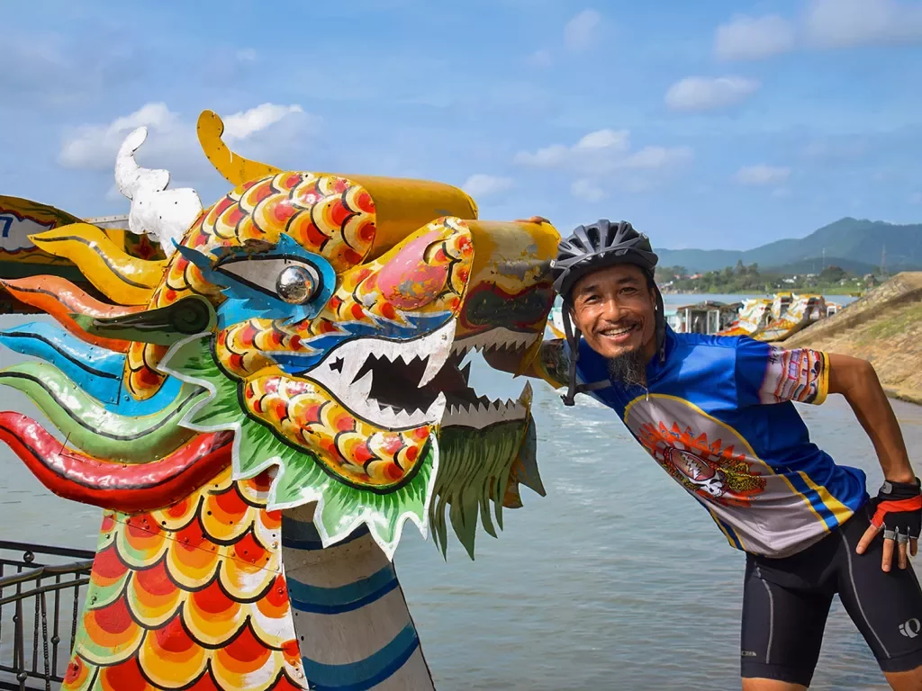 Guest posing with colorful dragon head sculpture.