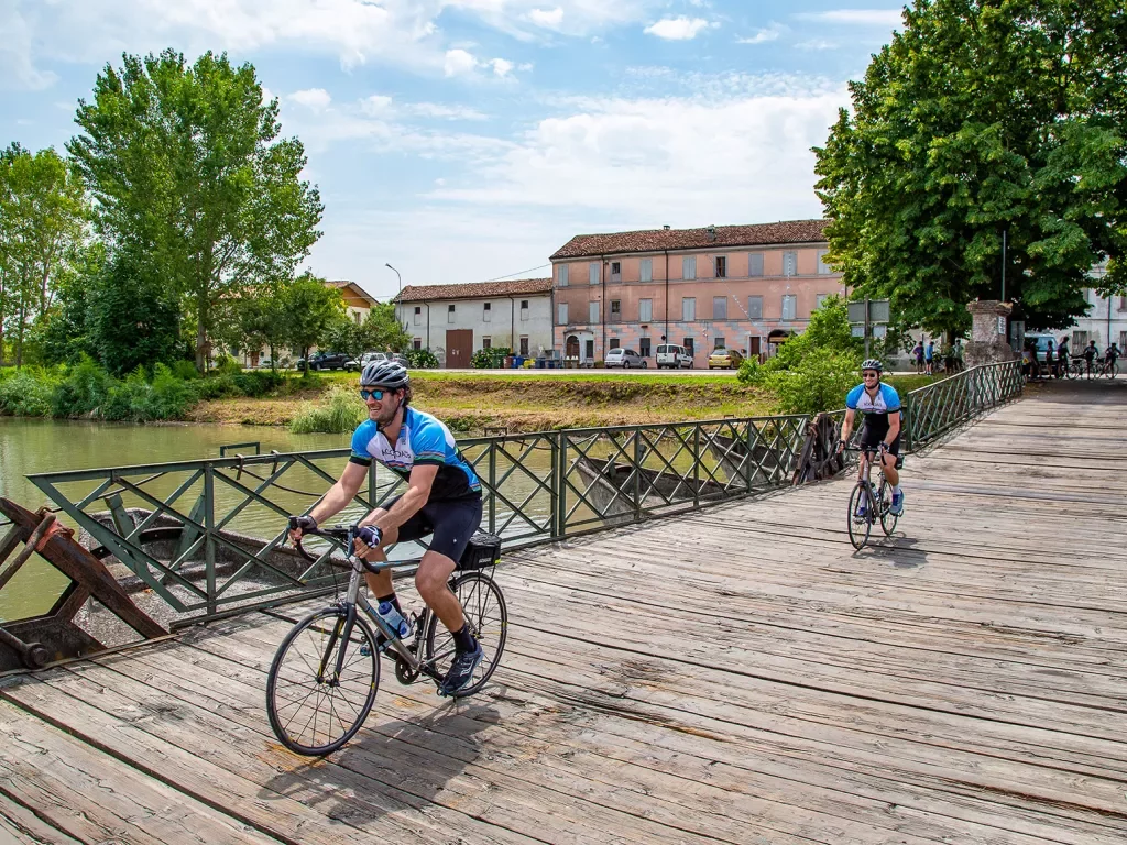 Cyclists crossing a wooden bridge in Veneto