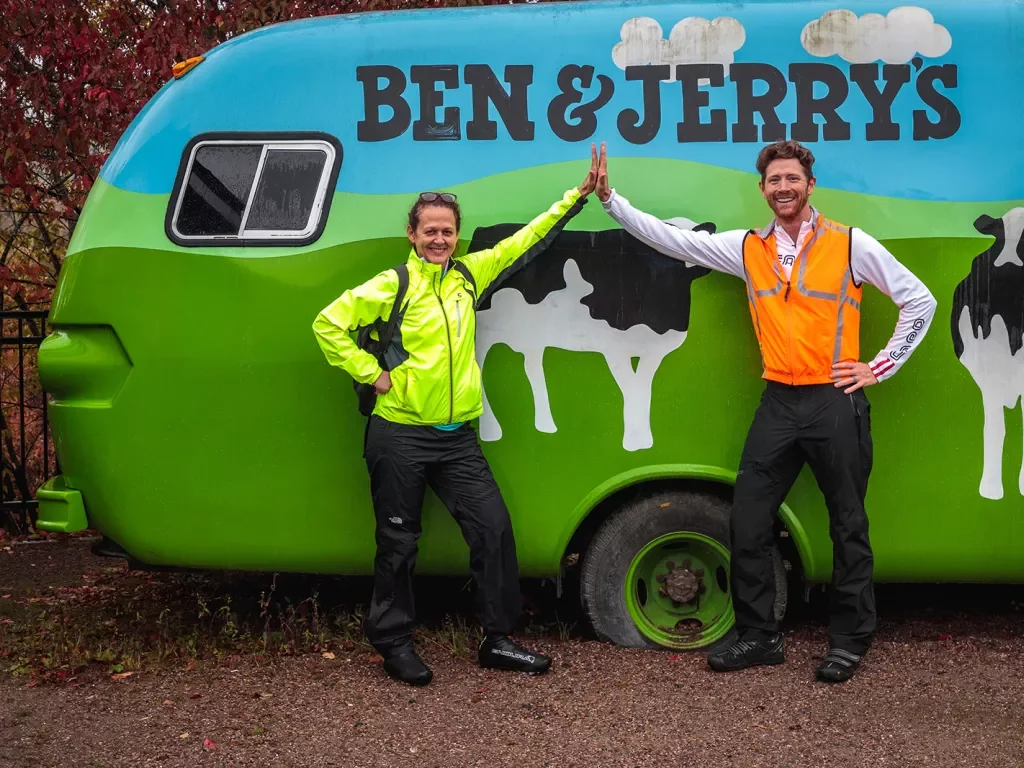 Two guests high-fiving in front of Ben & Jerry's car.