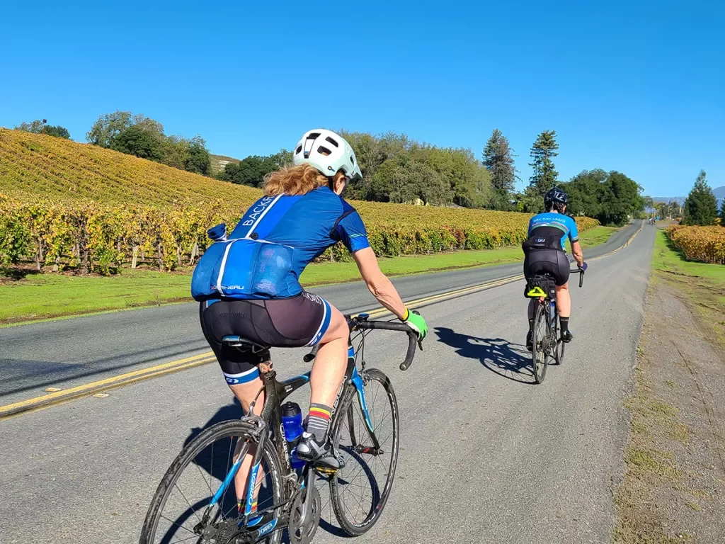 Two guests cycling amidst California vineyards.