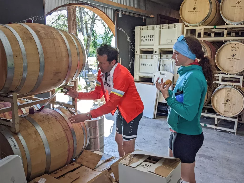 Guest/leader sampling wine from a barrel.