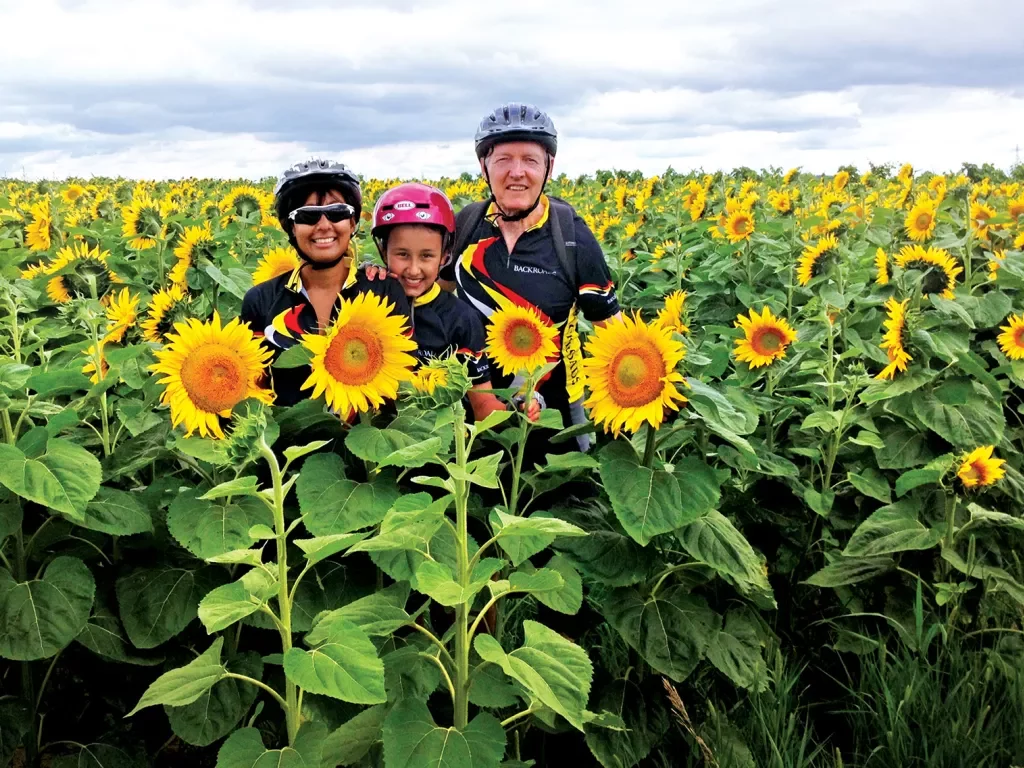 Backroads guests smiling among a field of sunflowers