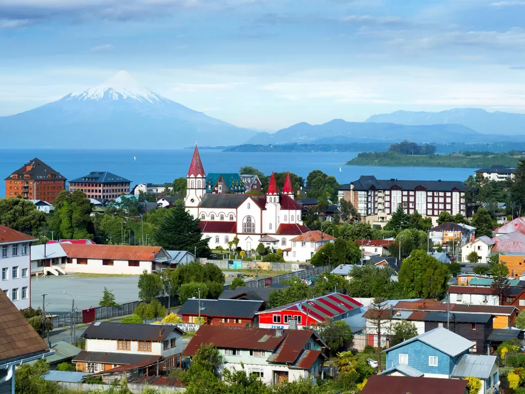 Wide shot of Lake Llanquihue, colorful red roofed houses.