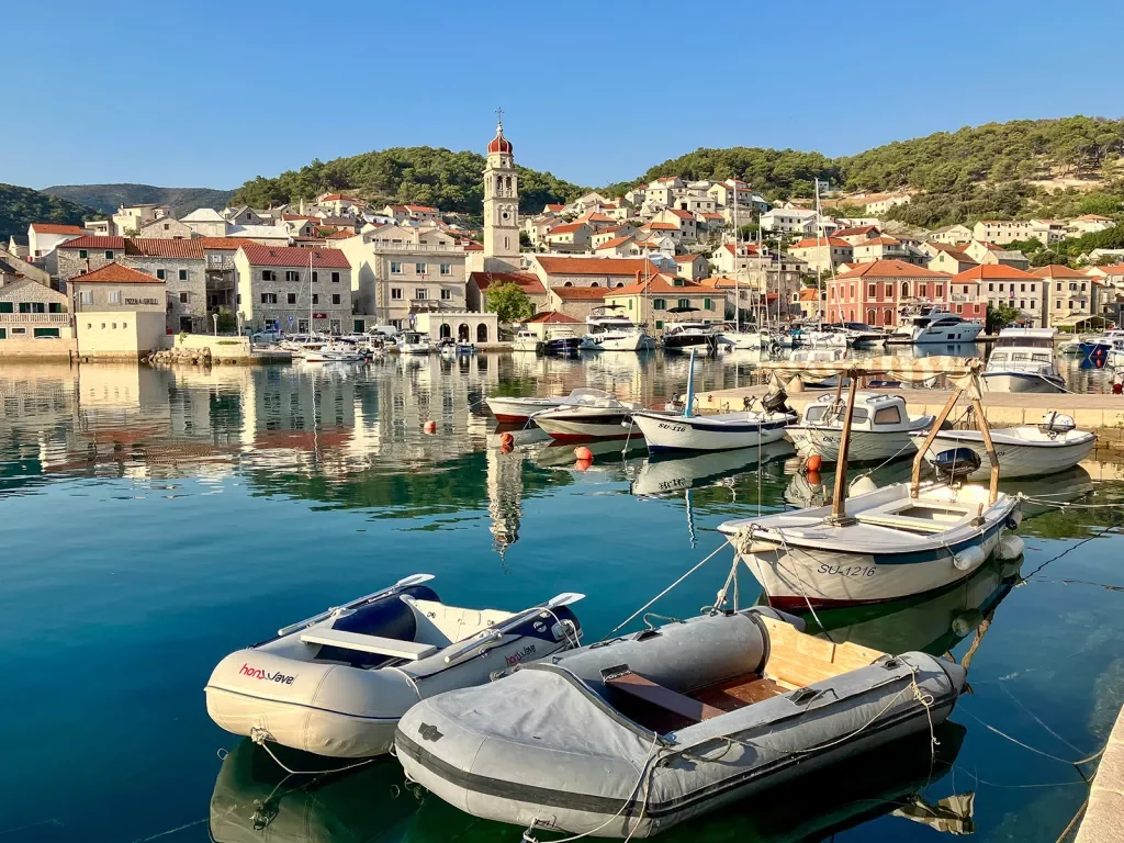 Wide shot of Croatian coast, boats, white and tan houses, etc.