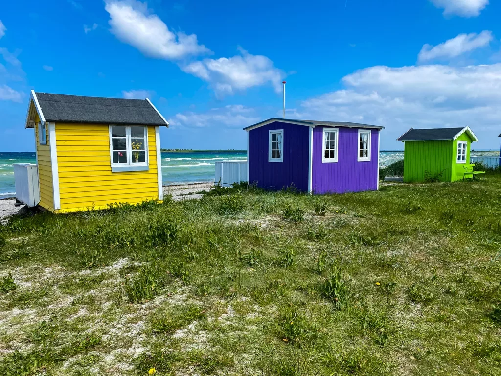Colorful huts along coast line + beach