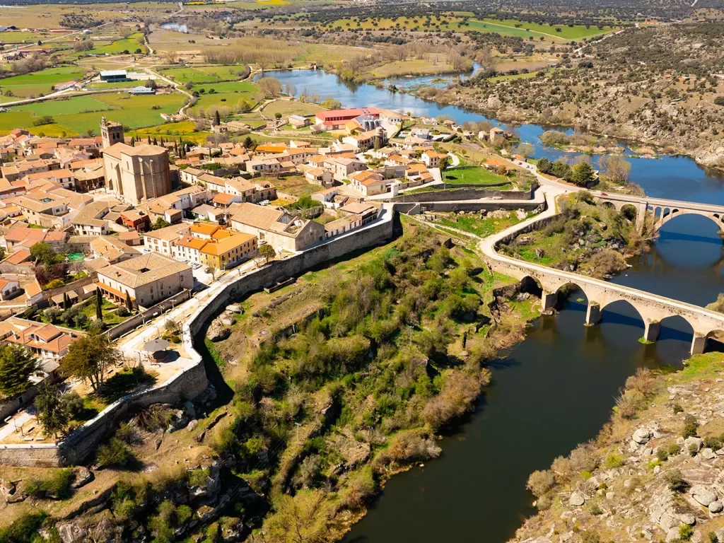 Bird's eye shot of Ledesma, Spain. River, bridges, walled city visible.