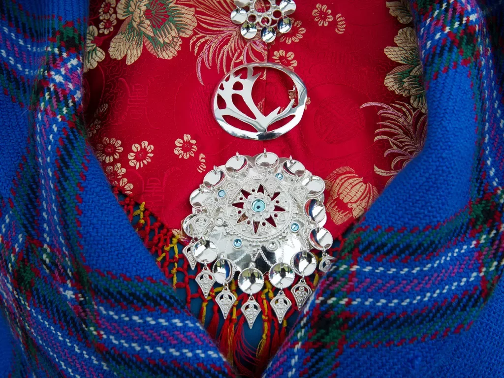Front shot of colorful dress, medallions, blanket.
