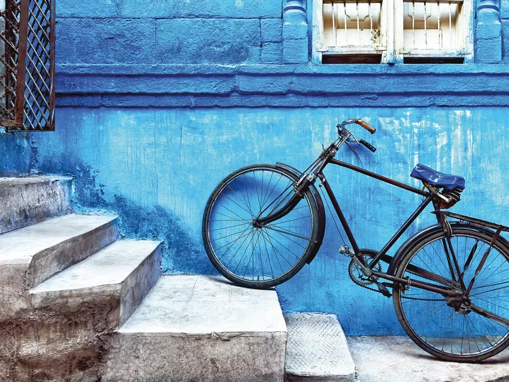 Bike sitting on the stairs against a blue wall