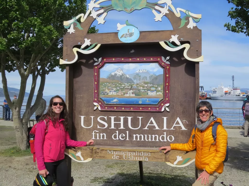 Two guests posing with a sign in Ushuaia