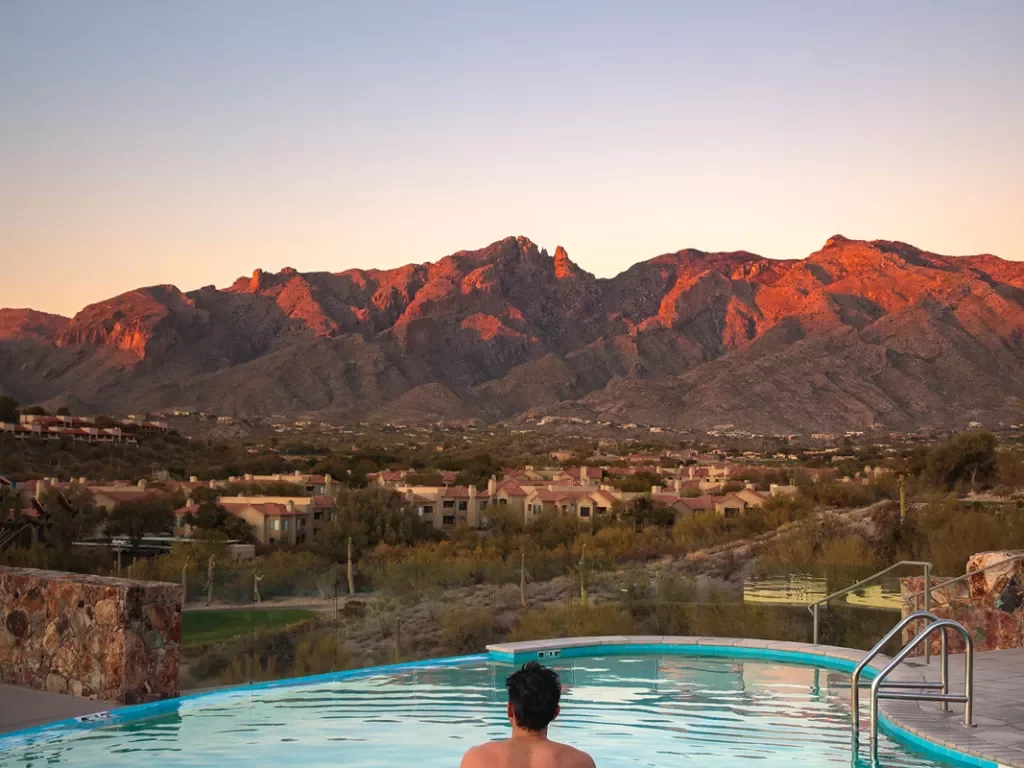 Back shot of male in hot tub at sunset in AZ