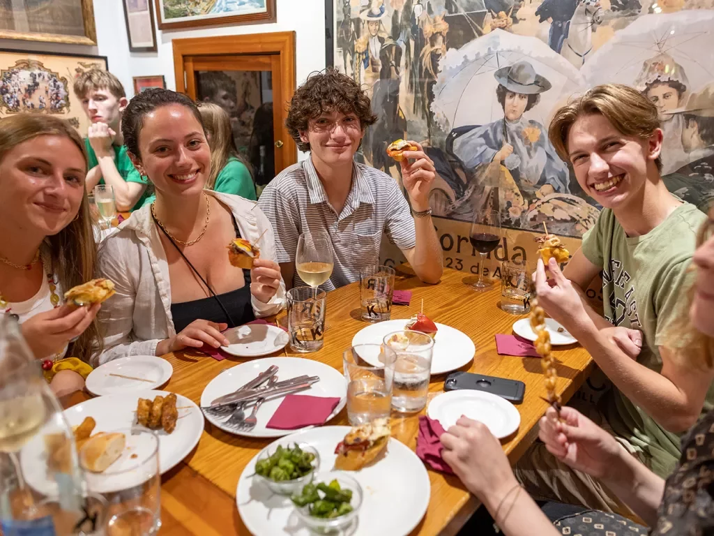 Group of young guests at meal, smiling at camera.