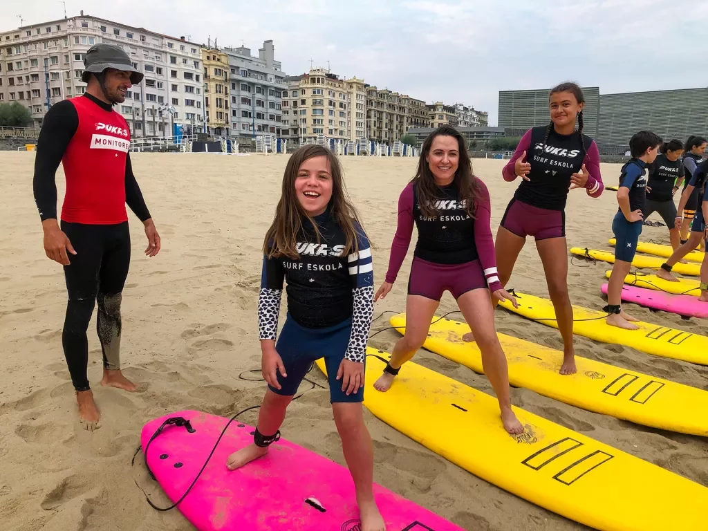 Group of young guests at surf lesson, instructor behind them.