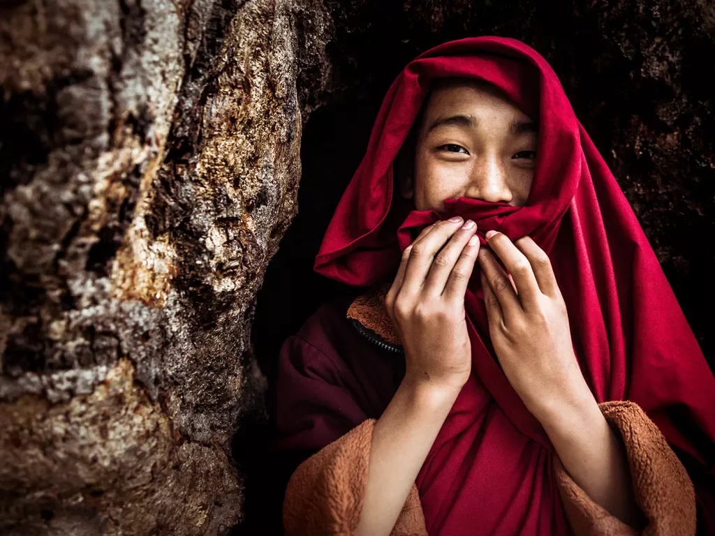 Monk smiling and covering their mouth in Bhutan