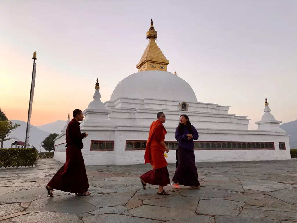 Three people walking beside a temple in Bhutan