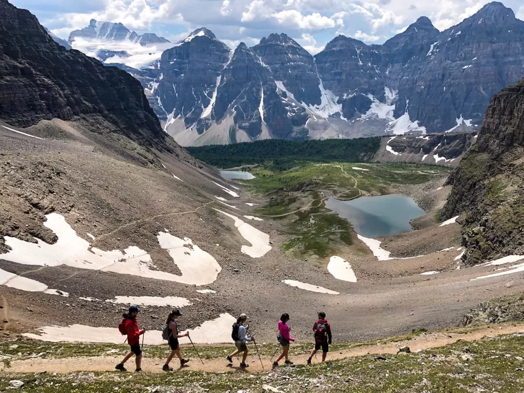 Five guests walking on gravel mountainside.