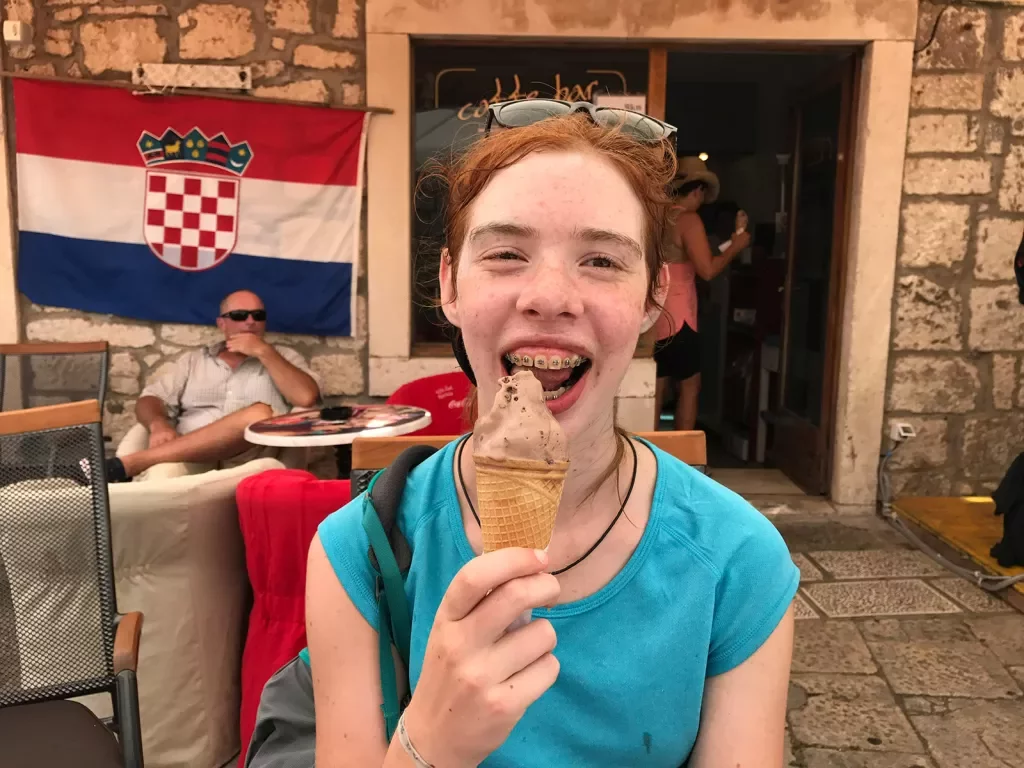 Young guest with ice cream cone, smiling at camera.