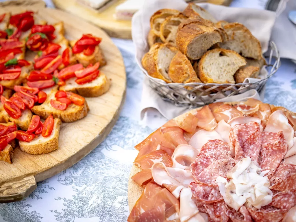 Platter of bread and tomatoes, cured meats, etc.