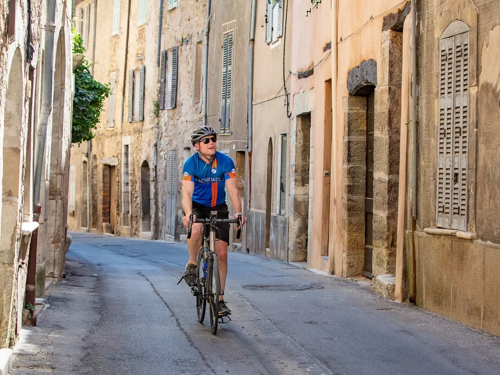 Biker riding riding through the old streets of a village in France