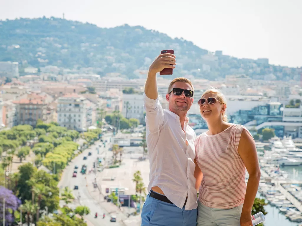 Two Backroads guests taking a selfie in front of a seaside town