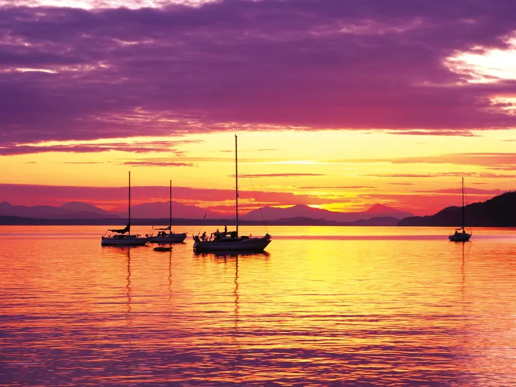 Sailboats anchored at Sunset at Montague Harbour Provincial Marine Park on Galiano Island in British Columbia Canada