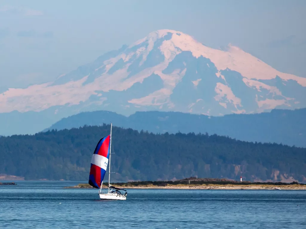 Wide shot of Mount Baker, small sailboat in foreground.