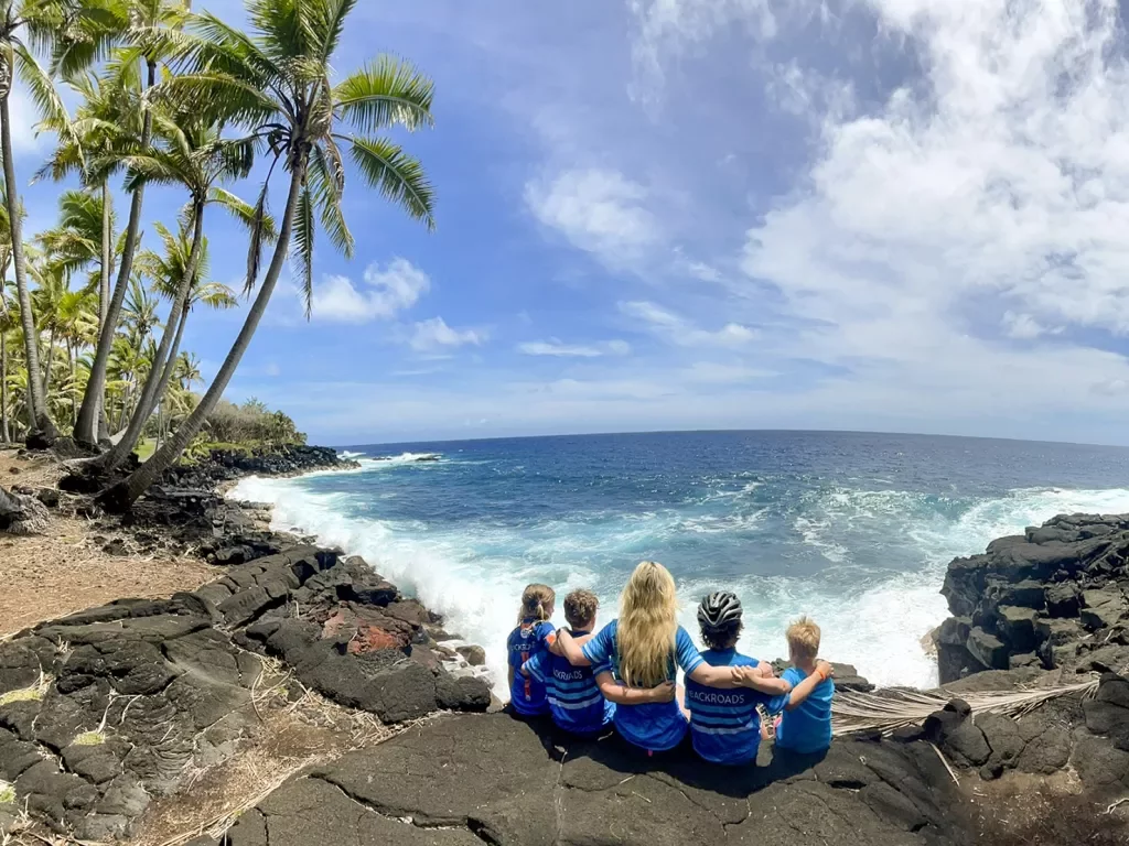 Family sitting by the ocean in Hawaii