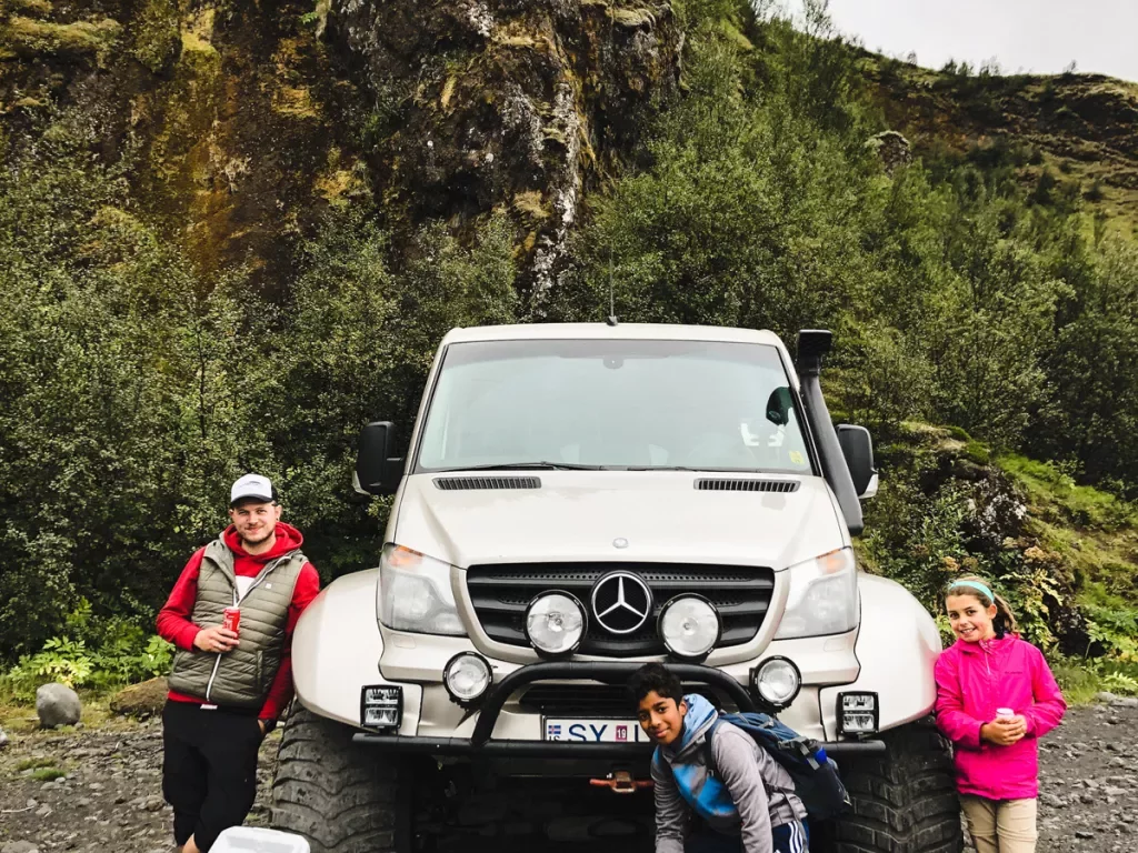 3 guests standing around a super Jeep in Iceland