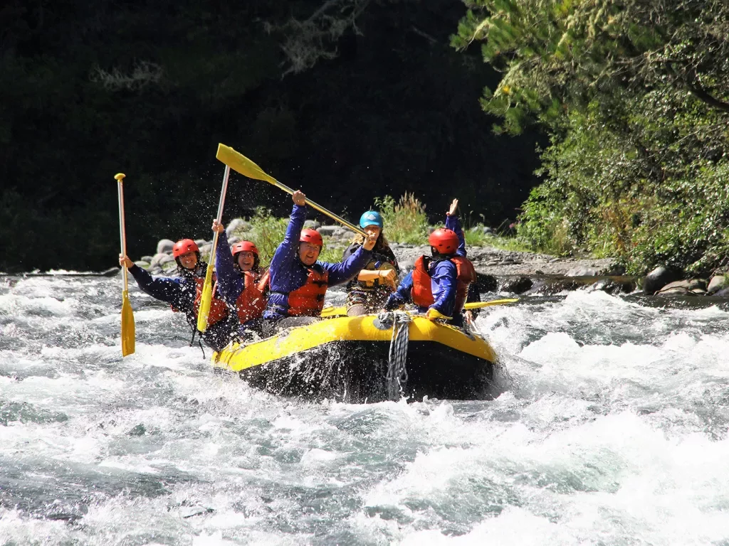 Five guests whit water rafting, all raising oars.