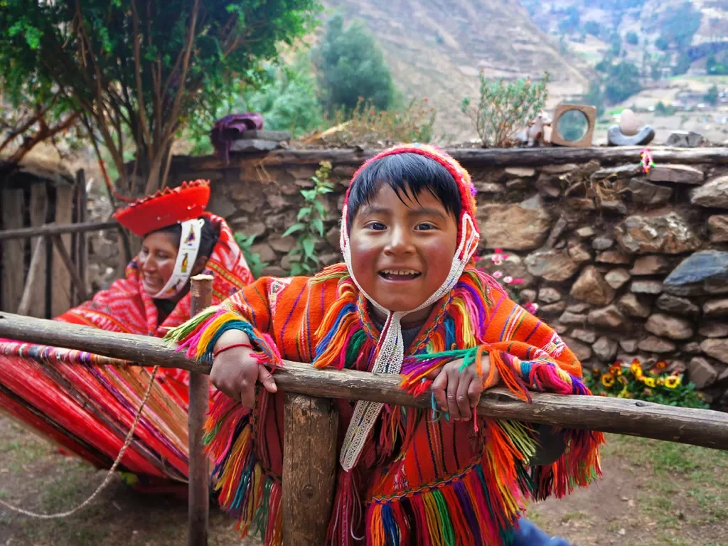 Two locals in colorful garb, one looking at camera, smiling.