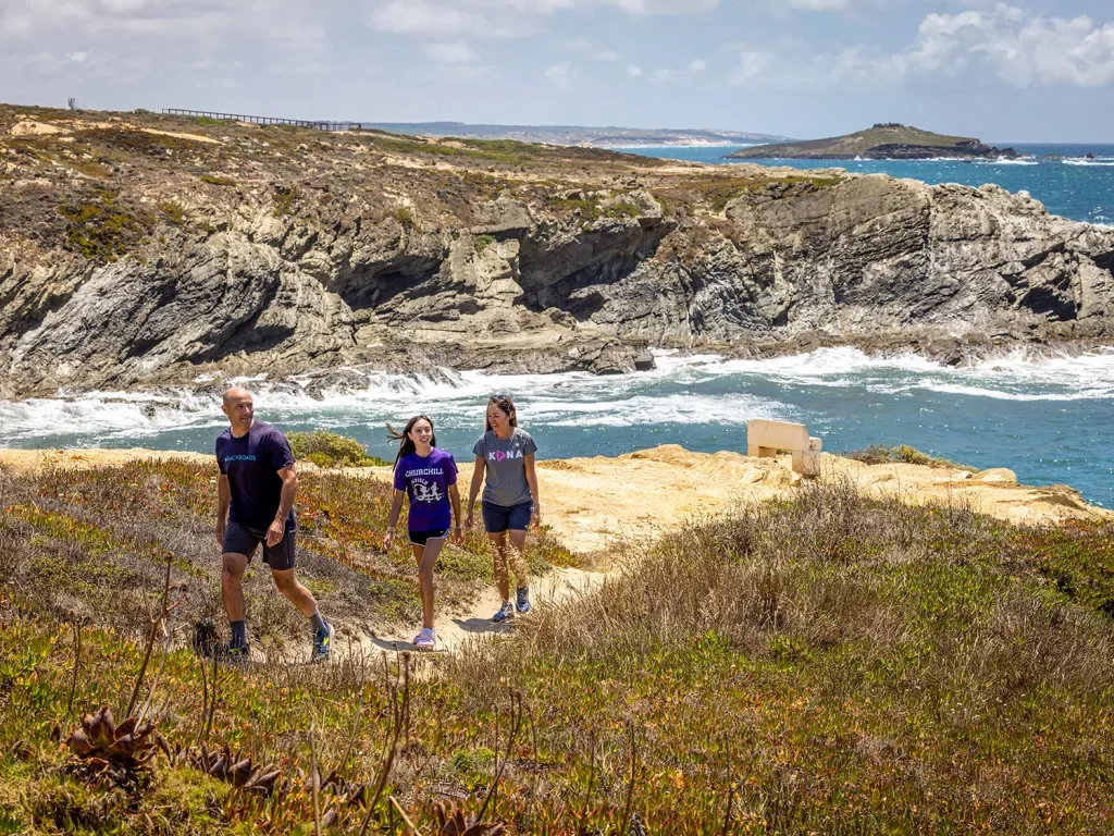 Hikers walking along a sandy path in Portugal