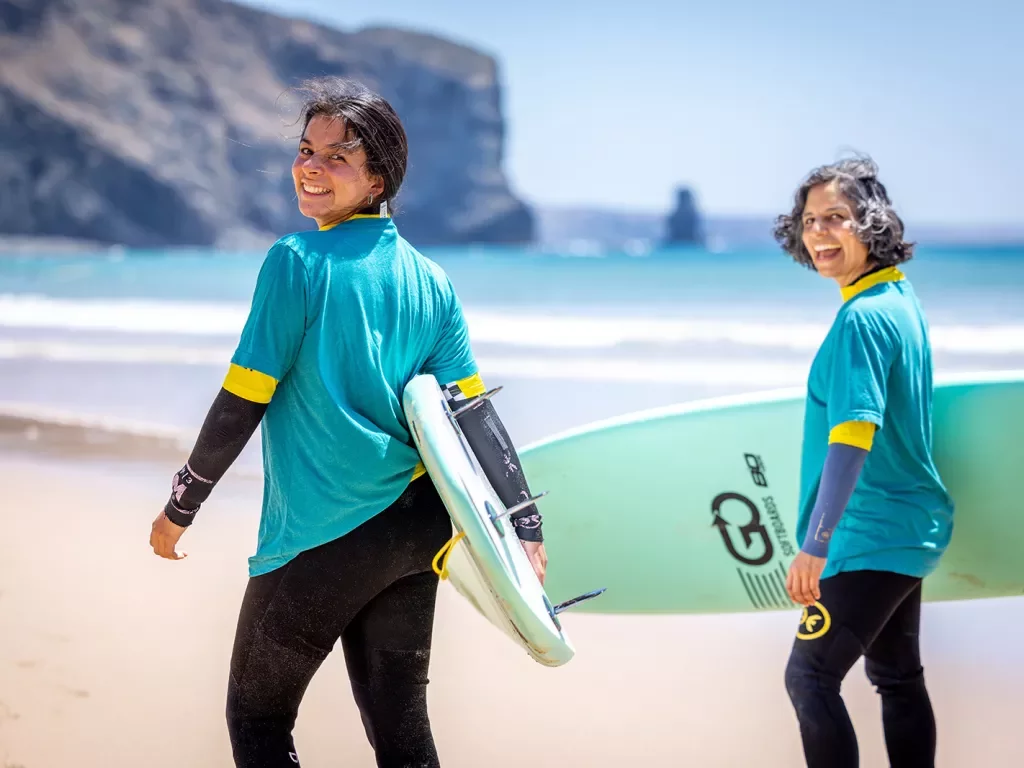Two women with surfboards walking towards the ocean