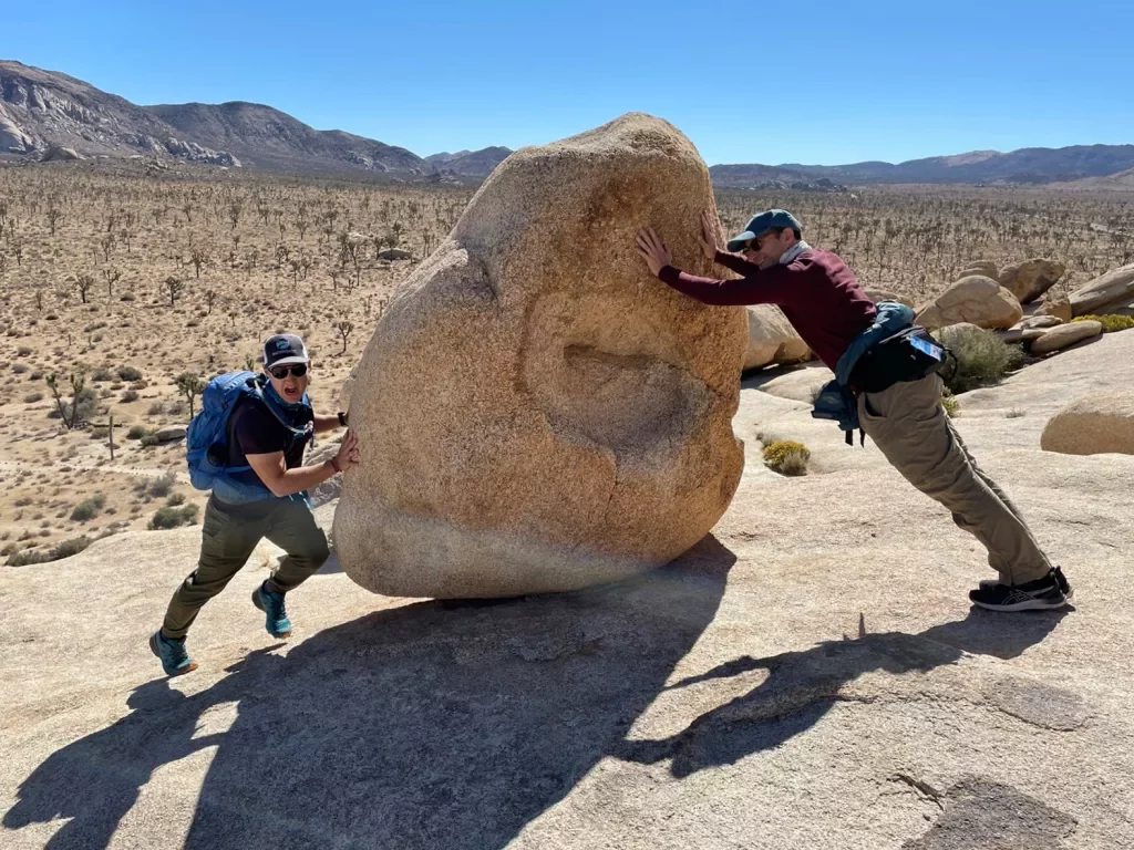 Guest and leader fake pushing a boulder.