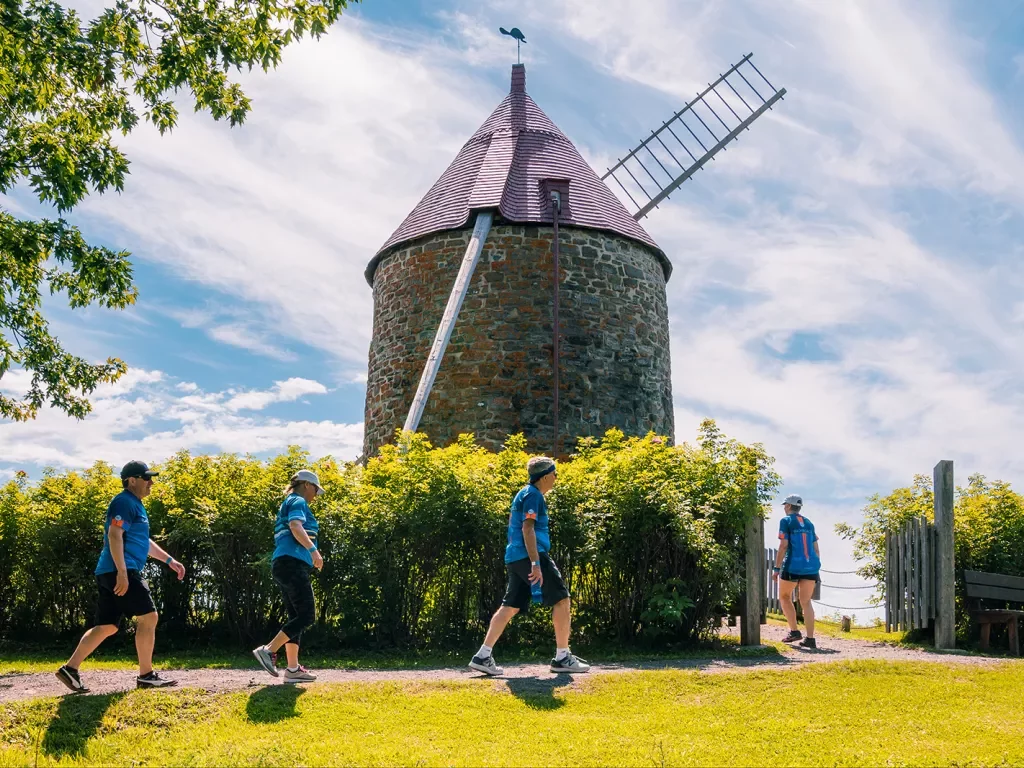 Four guests walking up towards windmill.