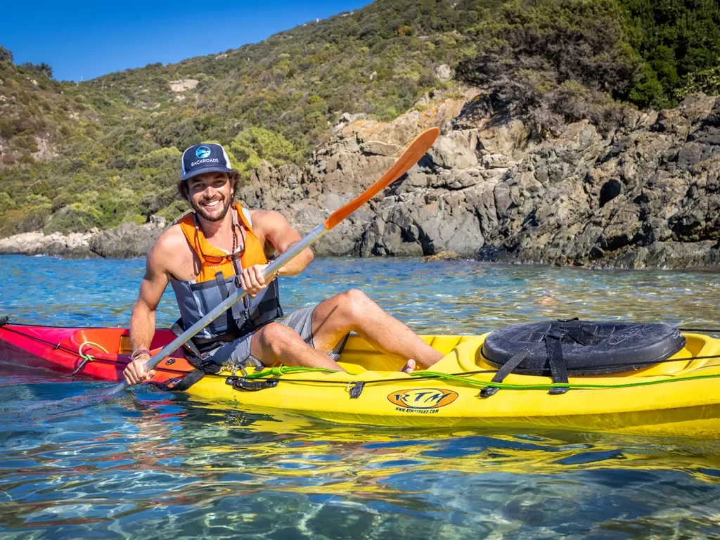 Man in a yellow kayak laughing 