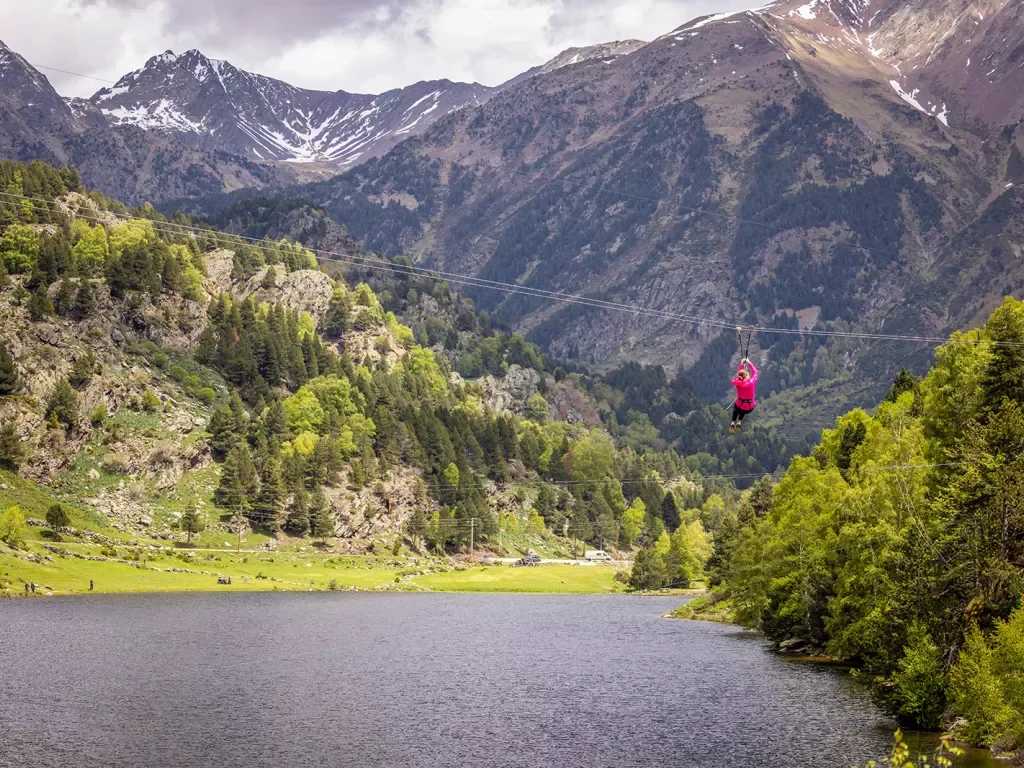 Person zip-lining across a lake