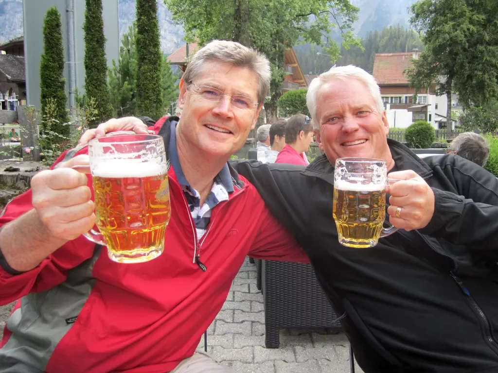 Two people saying cheers with mugs of beer.