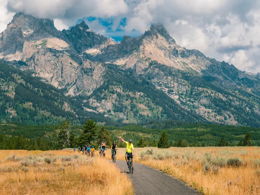 Backroads guests riding through golden fields and rocky mountains