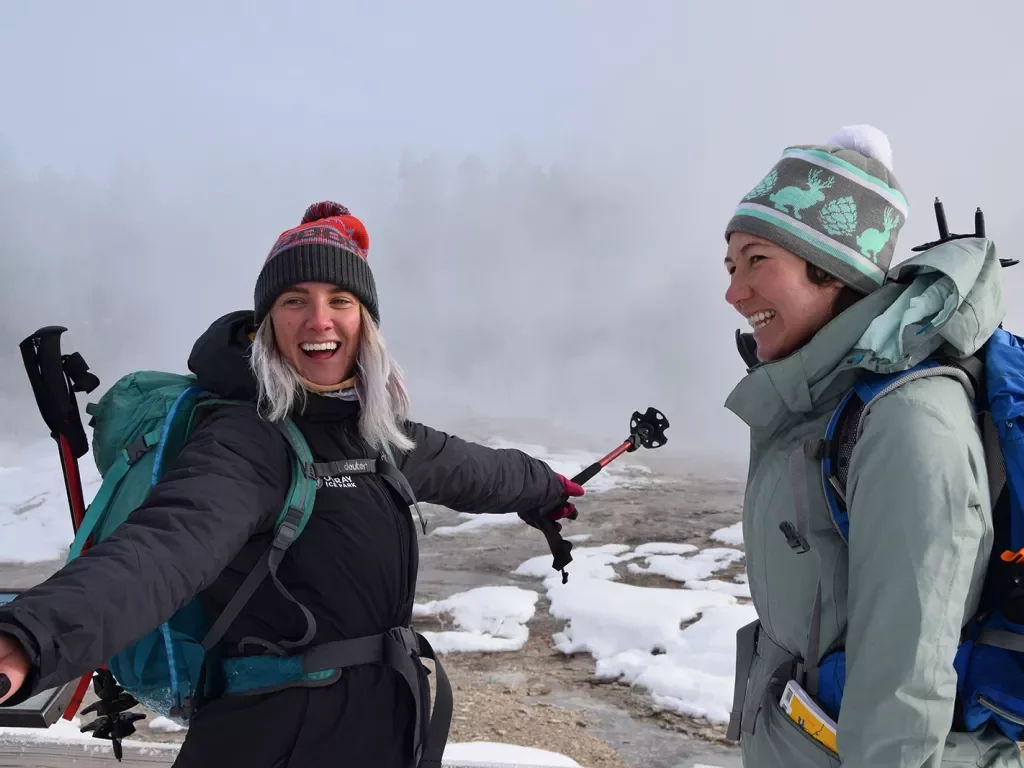 Backroads guests smiling near snowy hot springs