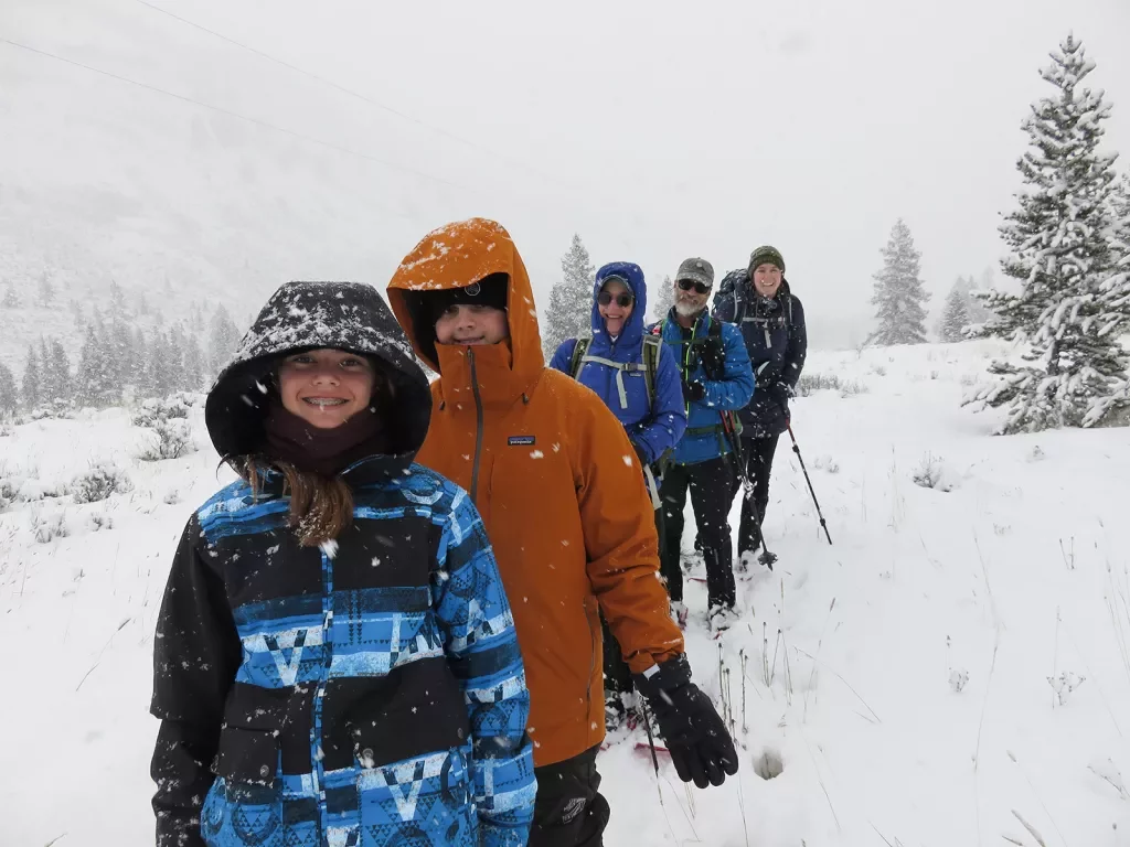 Backroads guests smiling while cross country skiing during blizzard