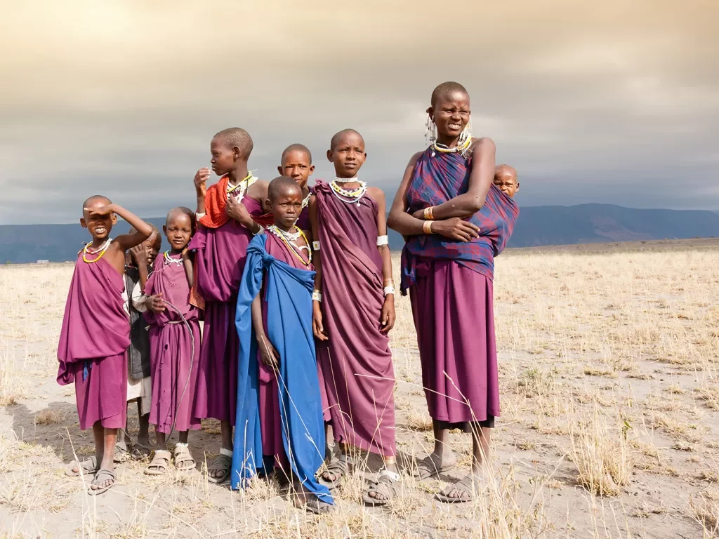 Masai woman and a children in the African savannah, looking at camera.Tanzania