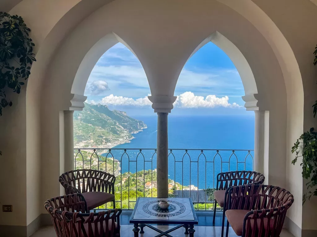 Shot of four chairs and table overlooking Italian coastline.